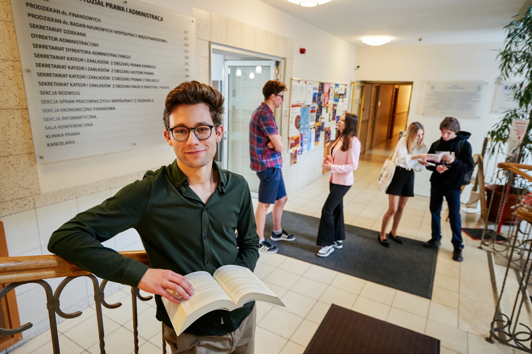 Student w holu Wydziału Prawa i Administracji UW